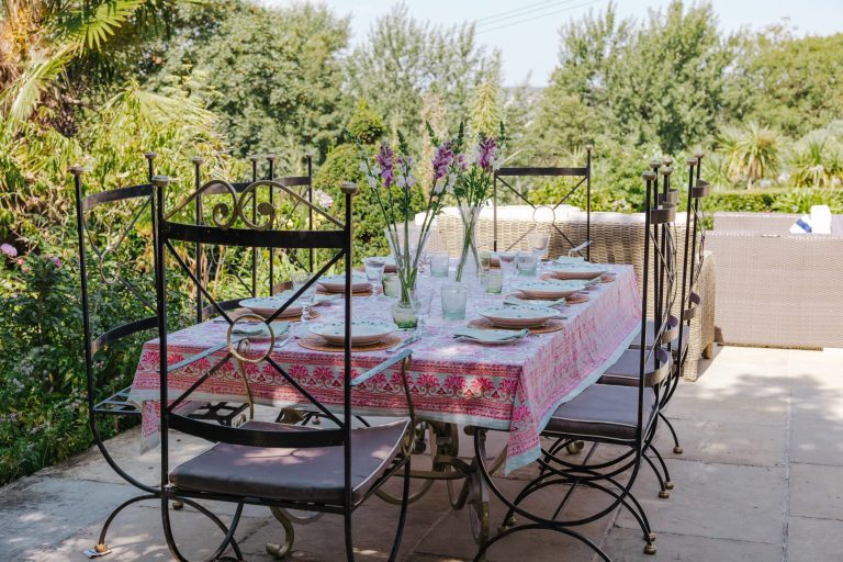 outdoor dining table on the patio, looking out over the gardens and sea