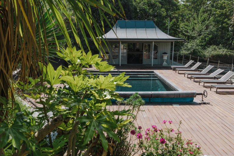 private swimming pool on the grounds of Shorelands in Bembridge on the Isle of Wight. Sun loungers and pool house