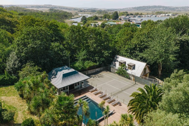 private tennis court next to the pool at a holiday home by the sea
