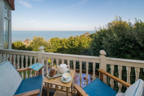 two chairs on the balcony at Bay House a large luxury 6 bedroom holiday home in Seaivew