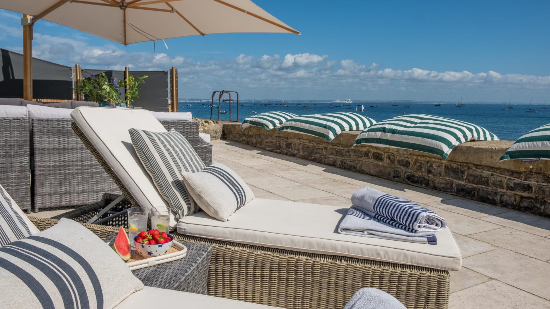 sun loungers on the terrace next to the beach looking across Seagrove Bay