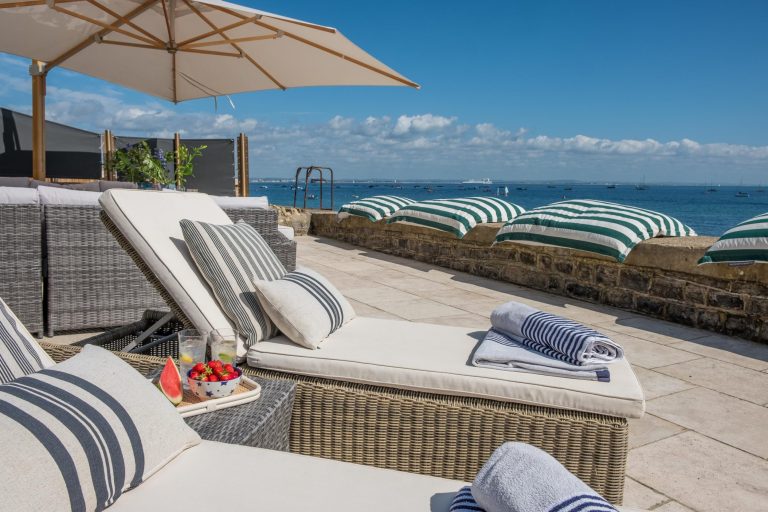 sun loungers on the terrace next to the beach looking across Seagrove Bay
