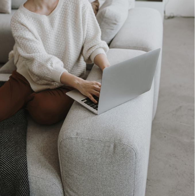 women sat on the sofa on her computer